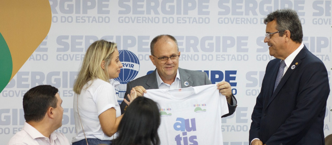 Mãe de criança com autismo, a senhora Priscilla Boaventura participou da solenidade e fez questão de parabenizar o governador Belivaldo Chagas e o deputado Luciano Pimentel presenteando-os com duas camisas enfatizando a causa - Fotos: Marco Vieira/ASN